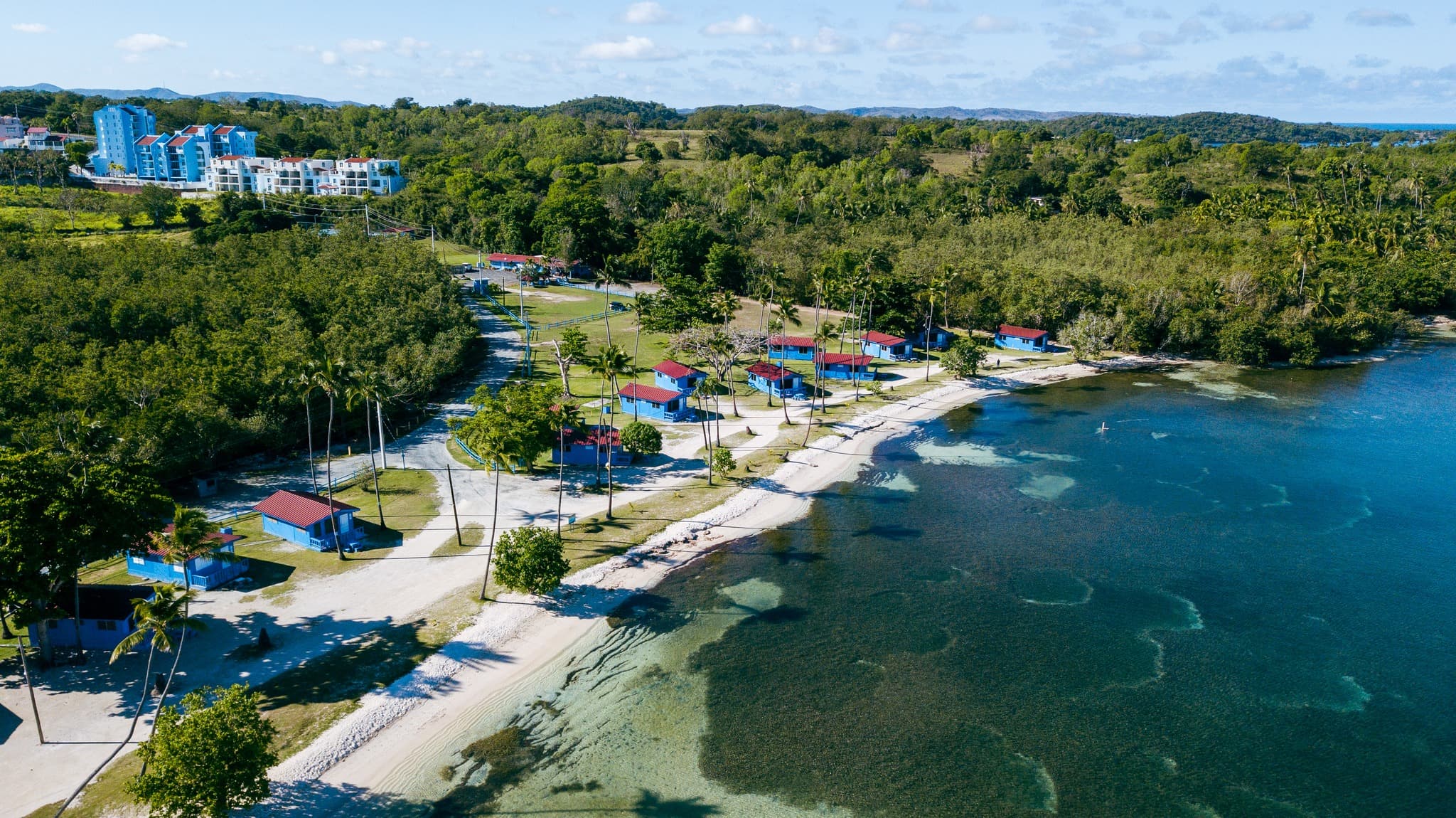Vista aérea panorámica de las cabañas de Villa La Mela y el mar turquesa de Cabo Rojo